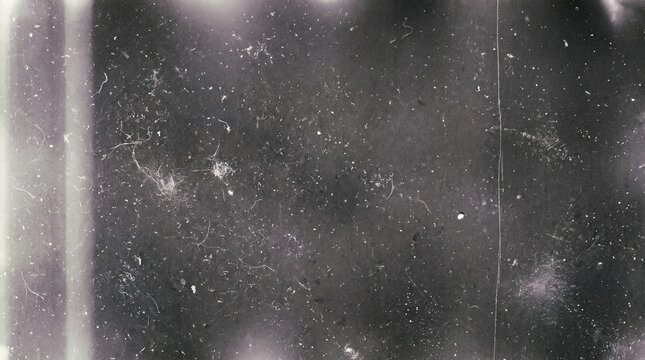 Vintage texture with dust, scratches, and light leaks on a dark grainy background