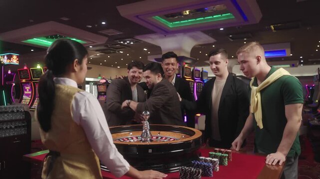 Players having fun and enjoying an exciting roulette game at a casino, placing bets and watching the roulette wheel spin. Cinematic casino atmosphere with red and black betting areas, gambling, entert