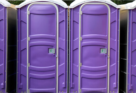 Two purple ports-potties standing side by side, nobody