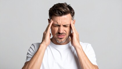 Man suffering from severe headache migraine pain rubbing temples on gray background