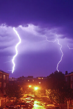 A dramatic scene of a lightning bolt striking through a vibrant purple sky, with dark clouds in the background. vertical frame