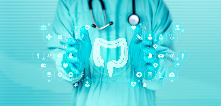 Technology applied to gastroenterology and digestive health. The doctor examines the large intestine icon, which stands out against an emerald green bokeh background.