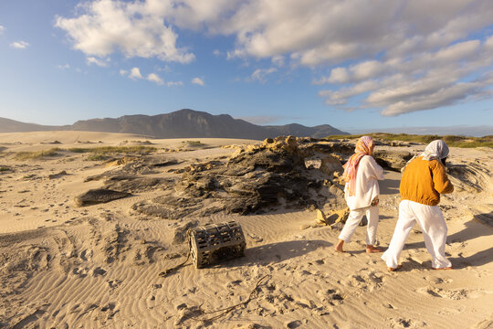 young women wrapped in scarves walking Sopies Klip, Walker Bay Nature Reserve, Stand South Africa at sunset