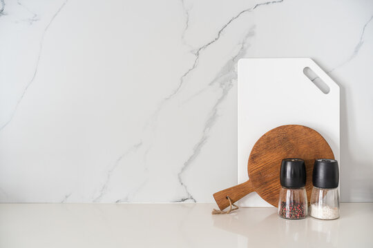 Kitchen utensils background with a blank space for a text and white marble background, home kitchen decor concept with kitchen tools, front view