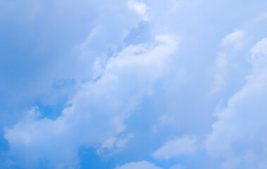 Obraz premium Clear blue sky background with soft white clouds on a bright sunny day.
