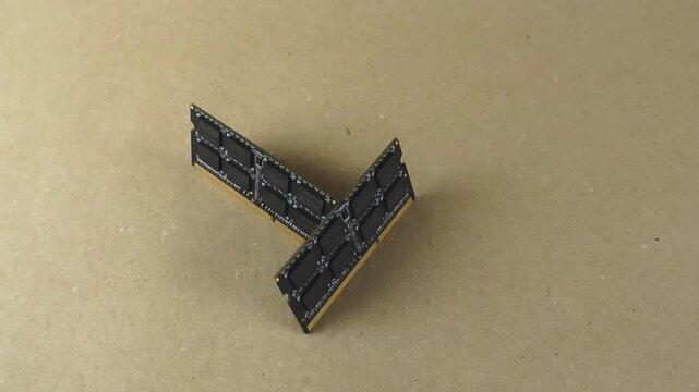 Two modern computer random access memory modules slowly rotating on a light brown background. Technological components for pc maintenance, repair and upgrade, improving system performance