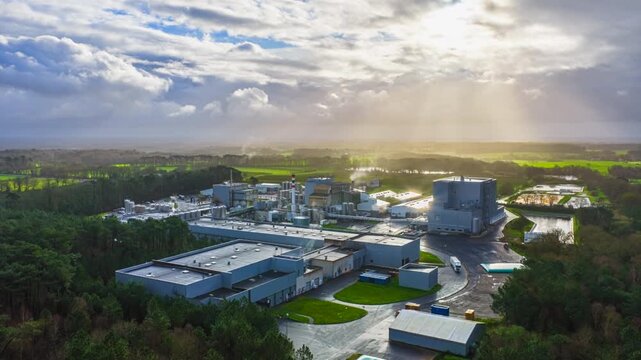 Industrial Manufacturing Plant And Facility Beneath Clouds At Sunrise In Germany. Aerial Timelapse Shot