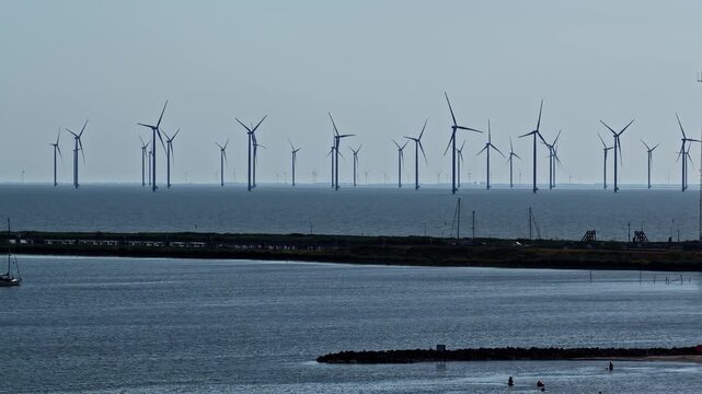 Wind Turbines Rise Across the IJsselmeer at Windpark Frysl&acirc;n, Breezanddijk, Netherlands - Aerial Drone Shot
