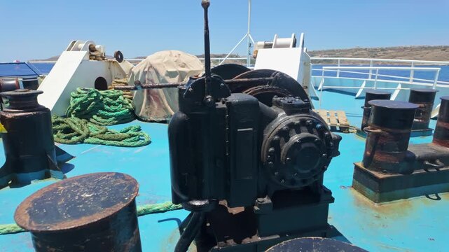 Gozo Channel passenger ferry deck with mooring ropes, chain and winch on the bow near Malta harbor, navigating the Mediterranean Sea on a sunny summer day.