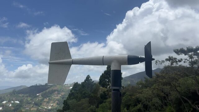 Weather vane and anemometer measuring wind direction on hilltop