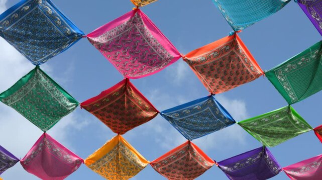 Bright papel picado banners sway overhead against a blue sky, creating a festive Mexican celebration background for events, tourism, and culture projects.