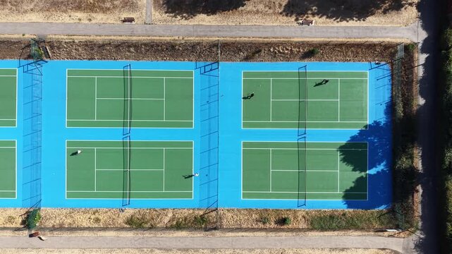 4K UHD drone rising pedestal shot over beautiful hard tennis courts on a clear, sunny day with a cloudless sky at Raphael Park, Romford, England