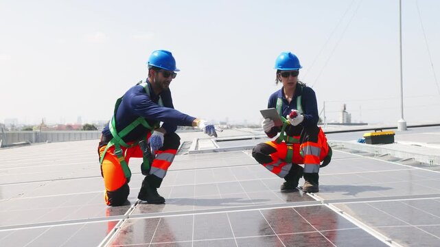 Two solar technicians inspecting rooftop photovoltaic panels, one adjusting panel alignment while colleague points and checks installation details.