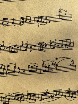 Close up of aged sheet music with musical notes and textured paper. Music notes Sheet on Aged Paper, black notes on brown paper, musical score, sheet music, musical notation, classical music 