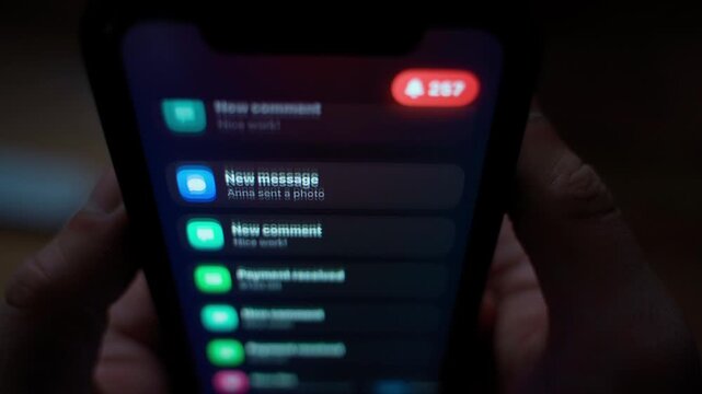 Many notifications arriving on smartphone screen in the dark close-up