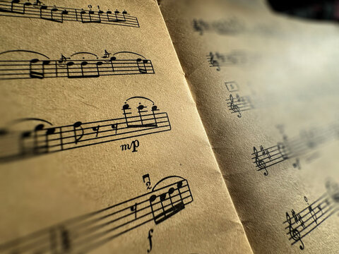 Close up of aged sheet music with musical notes and textured paper. Music notes Sheet on Aged Paper, black notes on brown paper, musical score, sheet music, musical notation, classical music 