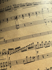 Fototapeta premium Close up of old sheet music with musical notes. Old musical score - no lyrics. Atmospheric music background with notes on old brown paper. For scrapbooking collage, journal design, and craft projects.