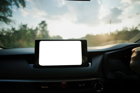 Driver uses clean car dashboard touchscreen while driving showing  white blank screen with symbols for navigation, music entertainment social media and technology.