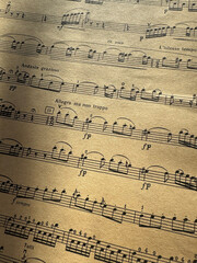 Fototapeta premium Close up of old sheet music with musical notes. Old musical score - no lyrics. Atmospheric music background with notes on old brown paper. For scrapbooking collage, journal design, and craft projects.