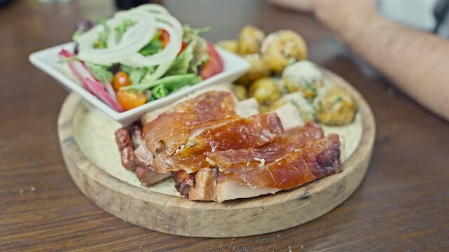 Peruvian roasted pork with crispy skin served with native potatoes 