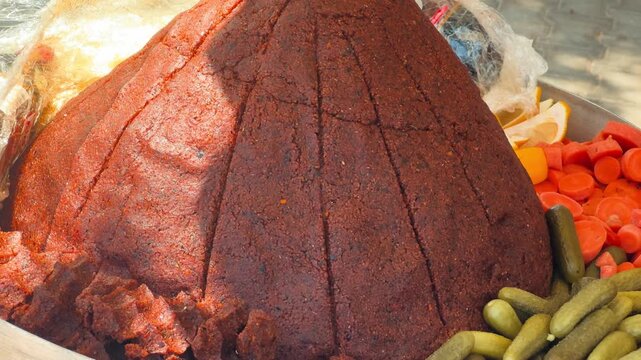 Muhammara spread shaped into a dome and sliced into wedges, served with pickles and carrots. High quality 4k footage
