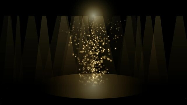 Golden glitter particles on a dark stage background