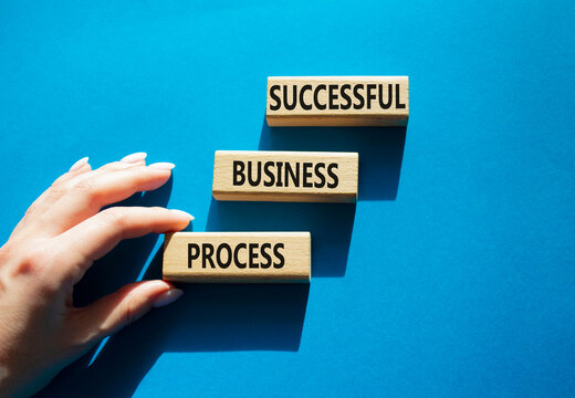 Concept words successful business process on wooden blocks arranged as steps. Businessman hand arranging wooden blocks. Business development concept. Blue background. Copy space.