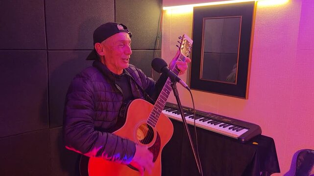 homem cantando e tocando viol&atilde;o acustico 
