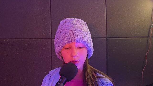 garota cantando em microfone no est&uacute;dio 