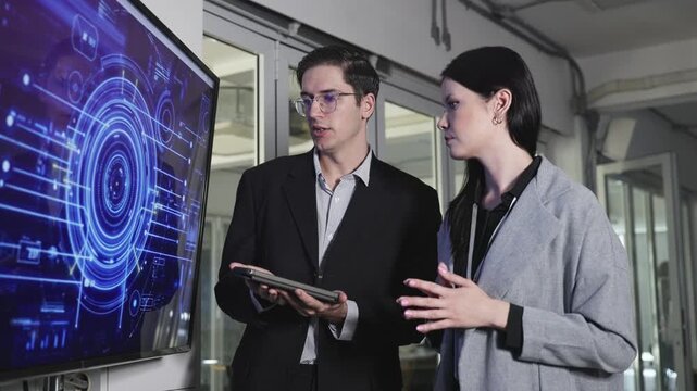 Three professionals in a business meeting setting with laptops, focused on a screen showing an AI-themed digital brain graphic and code.