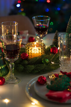 Cozy Christmas Eve Table Setting with Glowing Candle and Festive Decorations for a Family Gathering