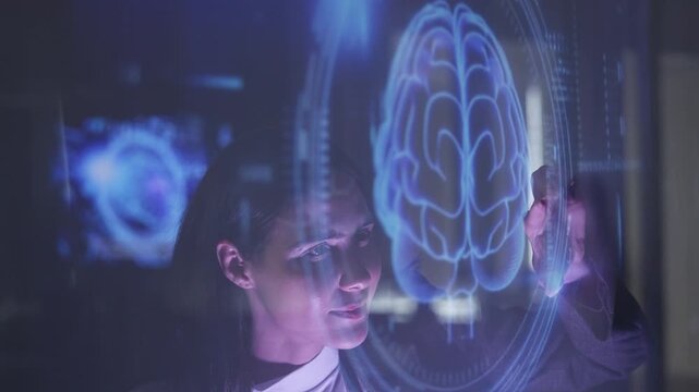Businesswoman touches a glowing blue holographic brain diagram on a transparent screen, symbolizing AI, neuroscience, or digital intelligence technologies.