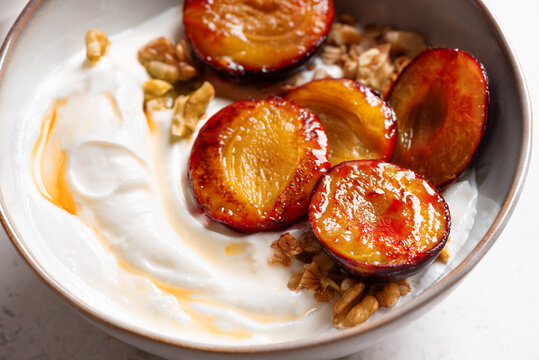 Roasted plums with yogurt, honey and nuts