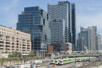 Obraz premium distant view of The Well, a mixed-use development at Front and Spadina, combining residences, offices, restaurants, and retail, Toronto (including Union Station Rail Corridor with Go Trains)