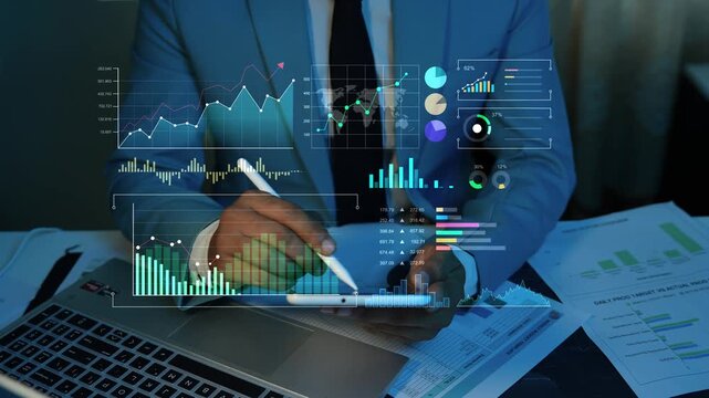 Holographic digital data graph chart dashboard animation, Businessman using a tablet at a desk with hologram financial charts, data dashboards, laptop reports and digital analytics overlay.