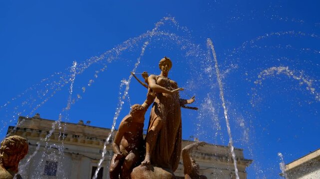 Syracuse, Sicily, Italy. Diana Fountain - Classic fountain with a statue of the goddess of the hunt Diana, created in 1907 by sculptor Giulio Moschetti. Sunny summer day