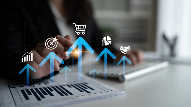 A professional workspace displaying hands engaged with business charts and graphs. The image symbolizes growth and success in finance and strategy development. Ledger