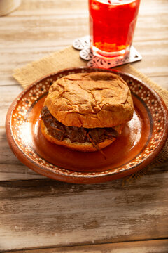 Authentic Mexican mole pastry sandwich on a rustic background. Tasty food photography with copy space. Mexican homemade food.