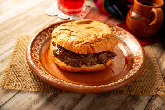 Authentic Mexican mole pastry sandwich on a rustic background. Tasty food photography with copy space. Mexican homemade food.