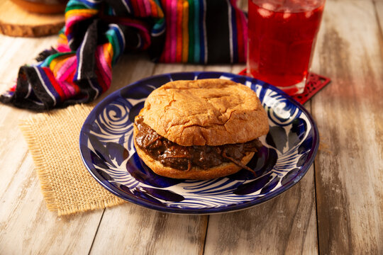 Authentic Mexican mole pastry sandwich on a rustic background. Tasty food photography with copy space. Mexican homemade food.