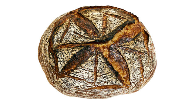 Isolated rustic artisan sourdough bread loaf with a dark, crackled crust and intricate scoring pattern
