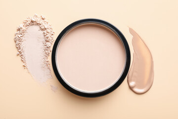Swatches of foundation and face powder on beige background, flat lay