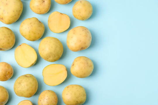Ripe raw young potatoes on light blue background, flat lay. Space for text