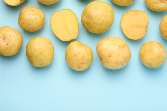 Ripe raw young potatoes on light blue background, flat lay. Space for text