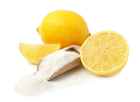 Baking soda in scoop and lemons isolated on white