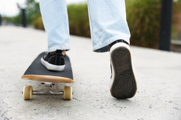 Man riding skateboard on city street, closeup © New Africa