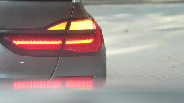 Car rear lamp assembly shows an amber turn indicator cycling beside illuminated red lamps, illustrating vehicle signaling and road traffic communication