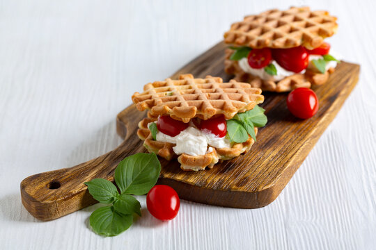 Zucchini waffles with cream cheese and cherry tomatoes.