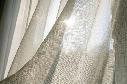 Sunlight through sheer curtains illuminating a room during the afternoon