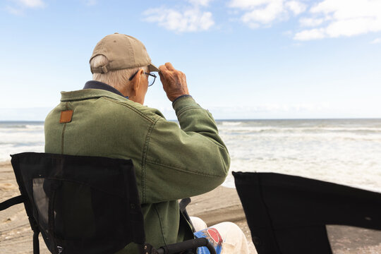 elderly man wearing baseball cap looking at Atlantis Ocean, South Africa